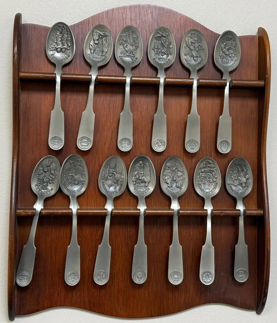 Franklin Mint 13 Original American Colonies pewter spoons with a wooden display rack. Coin Hub