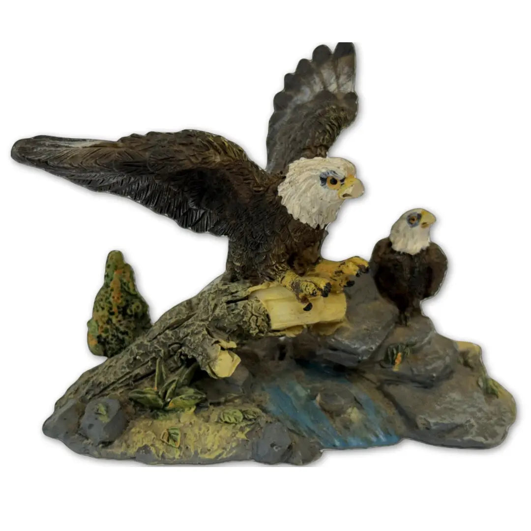 Sculpture features two bald eagles perched on a rock and branch formation